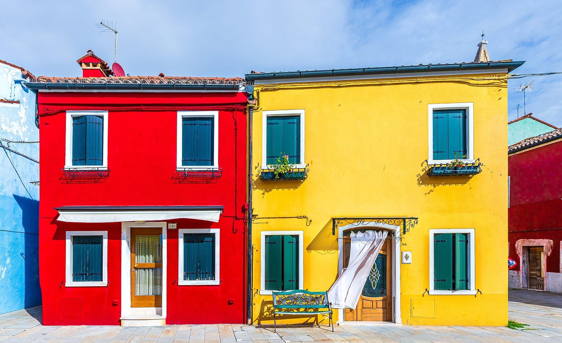 Case dai colori vivaci affacciate su un canale di Burano, con barche ormeggiate lungo la fondamenta