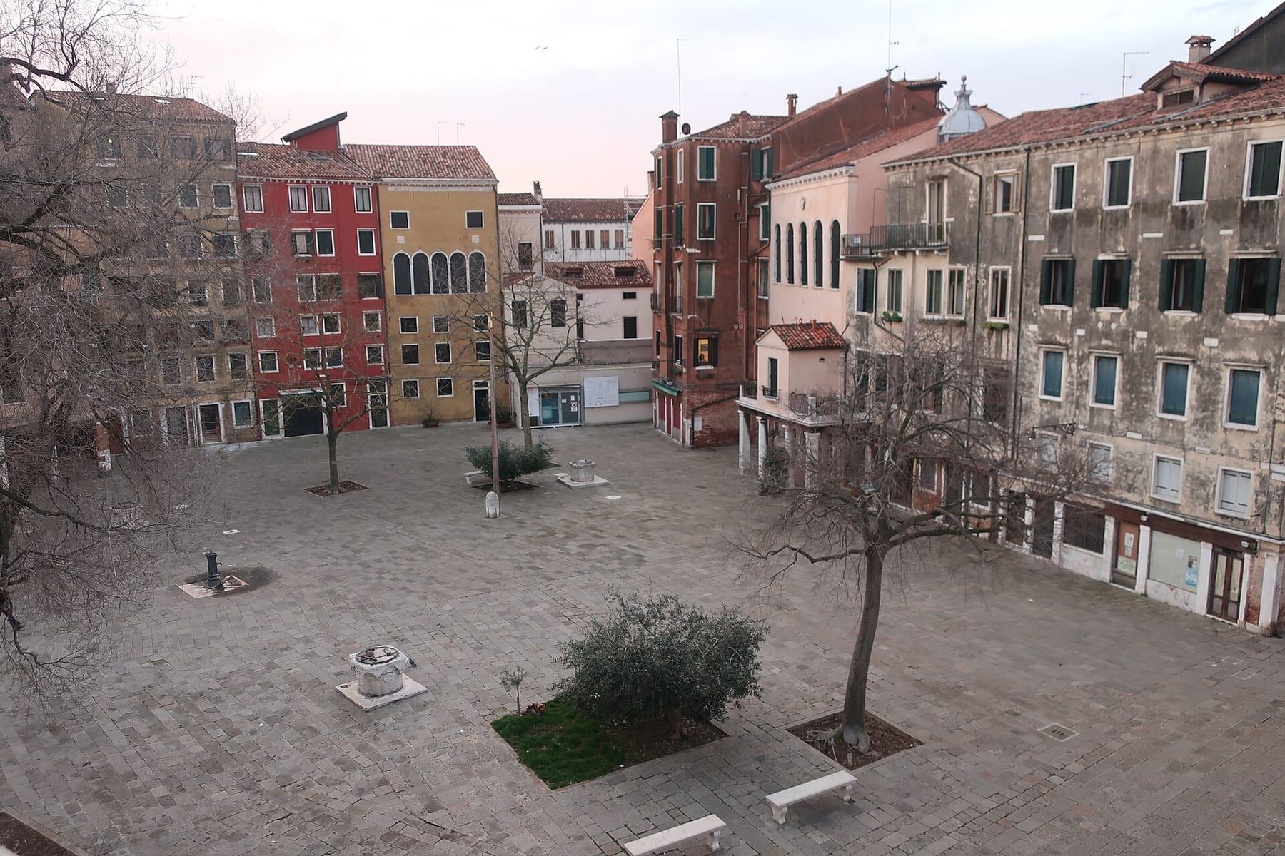 Der Campo del Ghetto Nuovo in Cannaregio mit hohen, vielgeschossigen Häusern und dem steinernen Brunnen in der Mitte