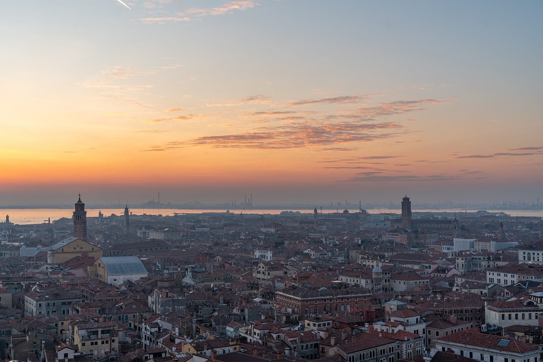 Luftpanorama über die Dächer Venedigs Richtung Lagune bei Sonnenuntergang, im Dunst
